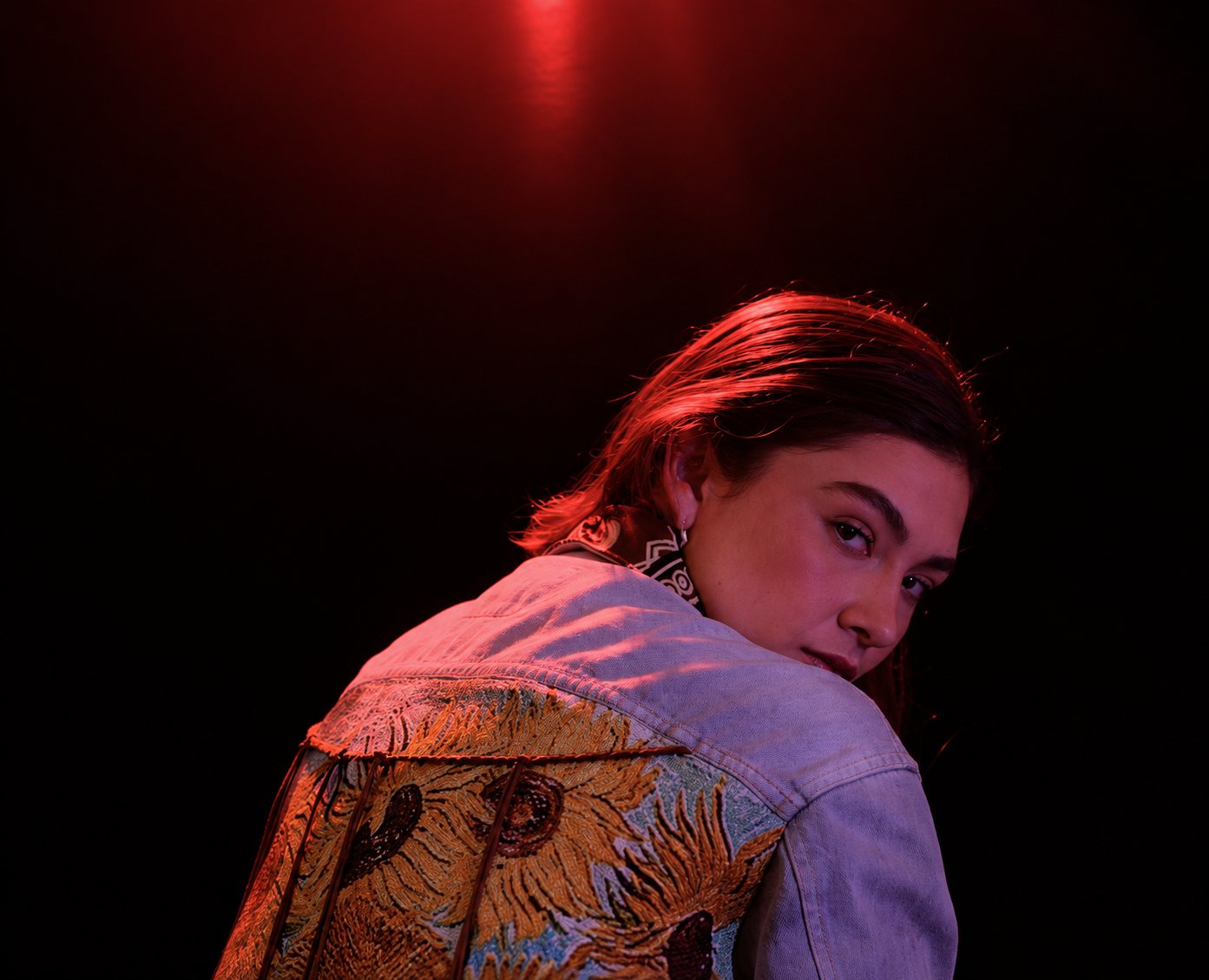Retrato de una mujer bajo iluminación roja para una producción de Ceniza
